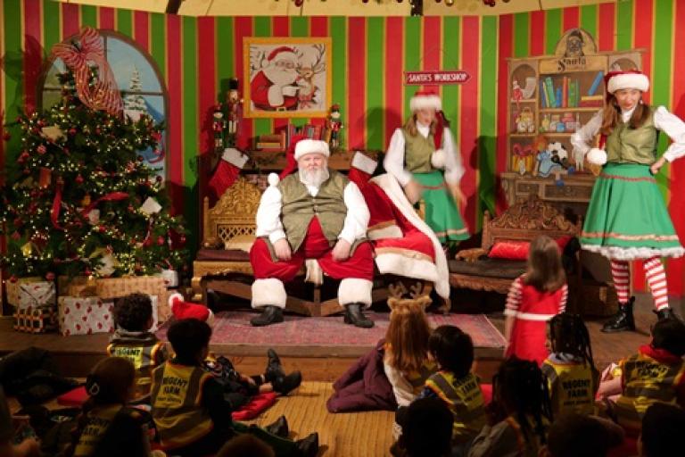 Children listening to story time by Santa in the Santa Stories workshop tent