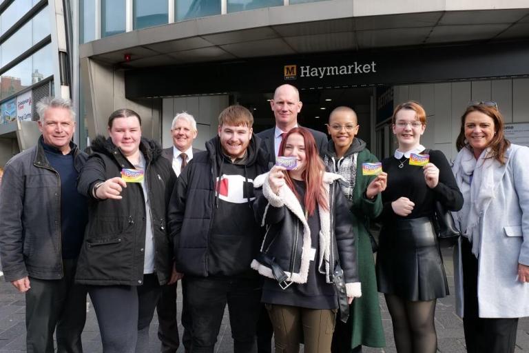 young people holding travel passes outside Haymarket 