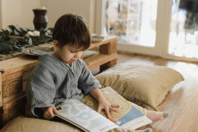 two year old boy reading a book 