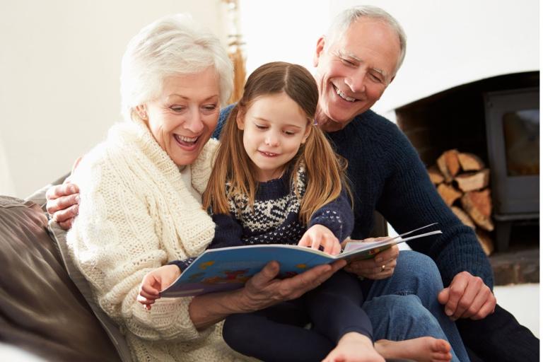 Grandparents reading book with child