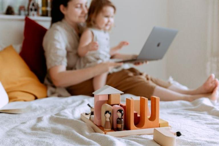 Child on mothers lap with toy in foreground