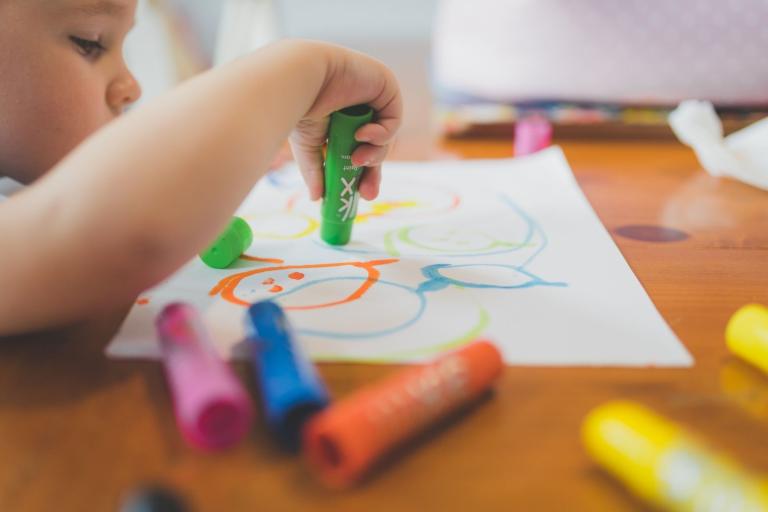 Child drawing with crayons