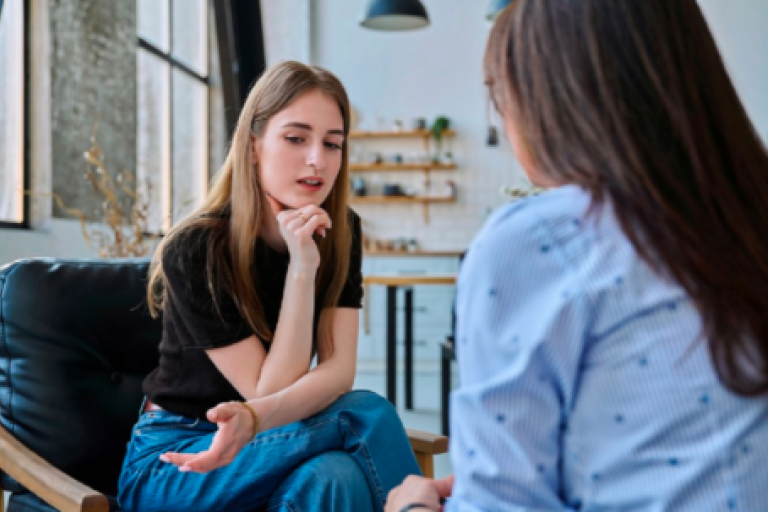 Young woman talking to professional