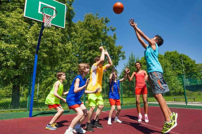 Children playing basket ball on court
